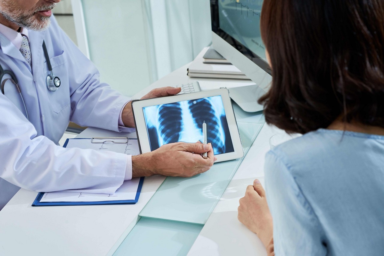 Doctor showing chest x-ray to female patient